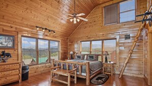 A log cabin bedroom with a wooden bed, a bench, a desk, and a ladder. - Luxurious Cabin|Majestic Views|Arcade|Hot Tub (Sevierville)