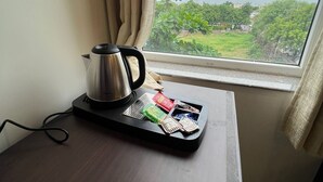 A room with a window, a kettle on a tray, and a table with some items on it. - Sheerha Royal Residency (Jaipur)