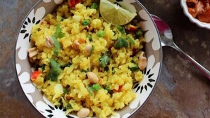 Two bowls of Poha Upma with a lime wedge, one on a patterned plate and another on a plain plate. - Sheerha Royal Residency (Jaipur)