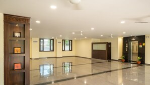 A spacious lobby with a polished floor, a wooden reception desk, and a modern elevator. - Sheerha Royal Residency (Jaipur)