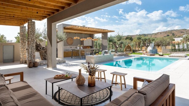 A covered outdoor area with a pool, seating, and a kitchen area. - Mirena Luxury Living - Casa di Maria (Αφάντου)