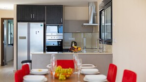 A modern kitchen with a built-in oven, microwave, and stainless steel refrigerator. - Villa ALEX by Abahana Villas (Benissa)