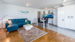 A modern living room with a blue sofa, a white coffee table, and a patterned rug. - Modern two bedrooms apartment Marea Blue with sea view in Funtana (Funtana)