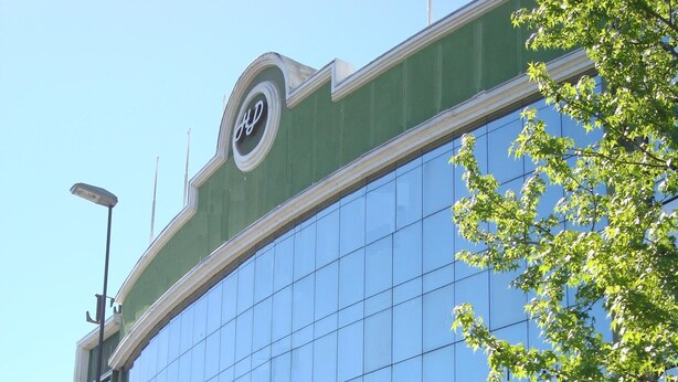 Een modern gebouw met een grote glazen gevel, waarop 