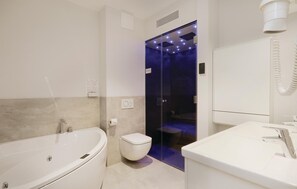 A modern bathroom with a freestanding bathtub, a toilet, and a sink. - Promenadenvilla (Lübeck)