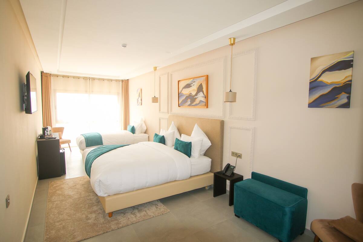 Ein Hotelzimmer mit einem großen Bett, einem Schreibtisch, einem Stuhl und einem Sofa.