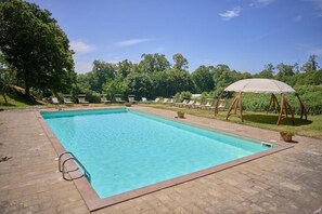 Una piscina al aire libre de temporada, tumbonas