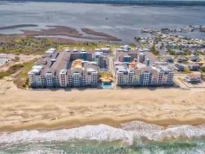 A coastal hotel with multiple buildings, a beach, and a marina.