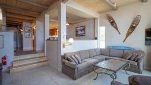 A spacious living area with a large L-shaped sectional sofa, a glass coffee table, and a wooden ceiling. - Star Harbor # 06 by Hauserman Rentals (Tahoe City)