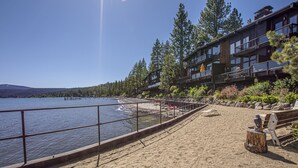 A beach with a wooden deck, a wooden bench, and a railing overlooking a lake. - Star Harbor # 06 by Hauserman Rentals (Tahoe City)