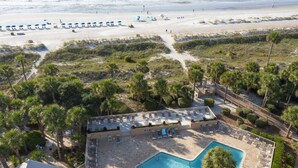 Un complexe hôtelier doté d’une piscine, d’un accès à la plage et de palmiers.