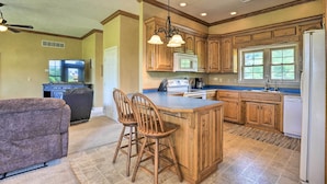 A kitchen with wooden cabinets, a built-in microwave, and a large window. - 'Angler's Ridge' Waterfront Family Getaway! (Mammoth Spring)