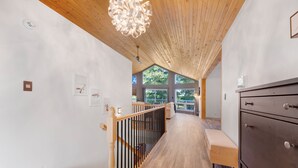 Un intérieur moderne avec un escalier en bois, un banc et une commode.