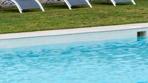 A swimming pool with clear water, surrounded by a grassy area and white poolside chairs. - H. Doble Nómadas - One Bedroom Hotel, Sleeps 2 (Vejer de la Frontera)
