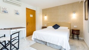A bedroom with a bed, a desk, and a chair. There are two nightstands with lamps. - H. Doble Nómadas - One Bedroom Hotel, Sleeps 2 (Vejer de la Frontera)