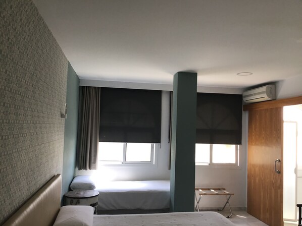 Un dormitorio con cama, ventana, armario y radiador.