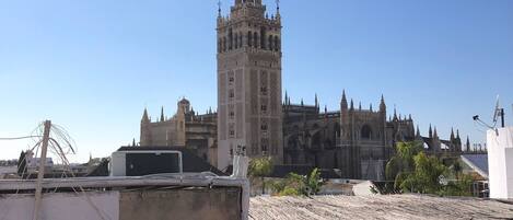 A view of a historic building with intricate architecture, including a prominent tower and multiple spires.