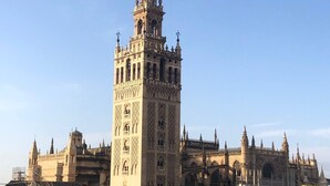 Una torre històrica d'arquitectura complexa, envoltada d'altres edificis.