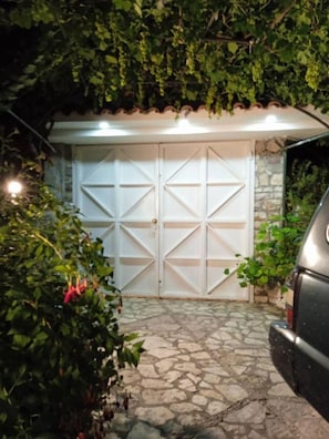 Drive up to an entrance surrounded by lush greenery.