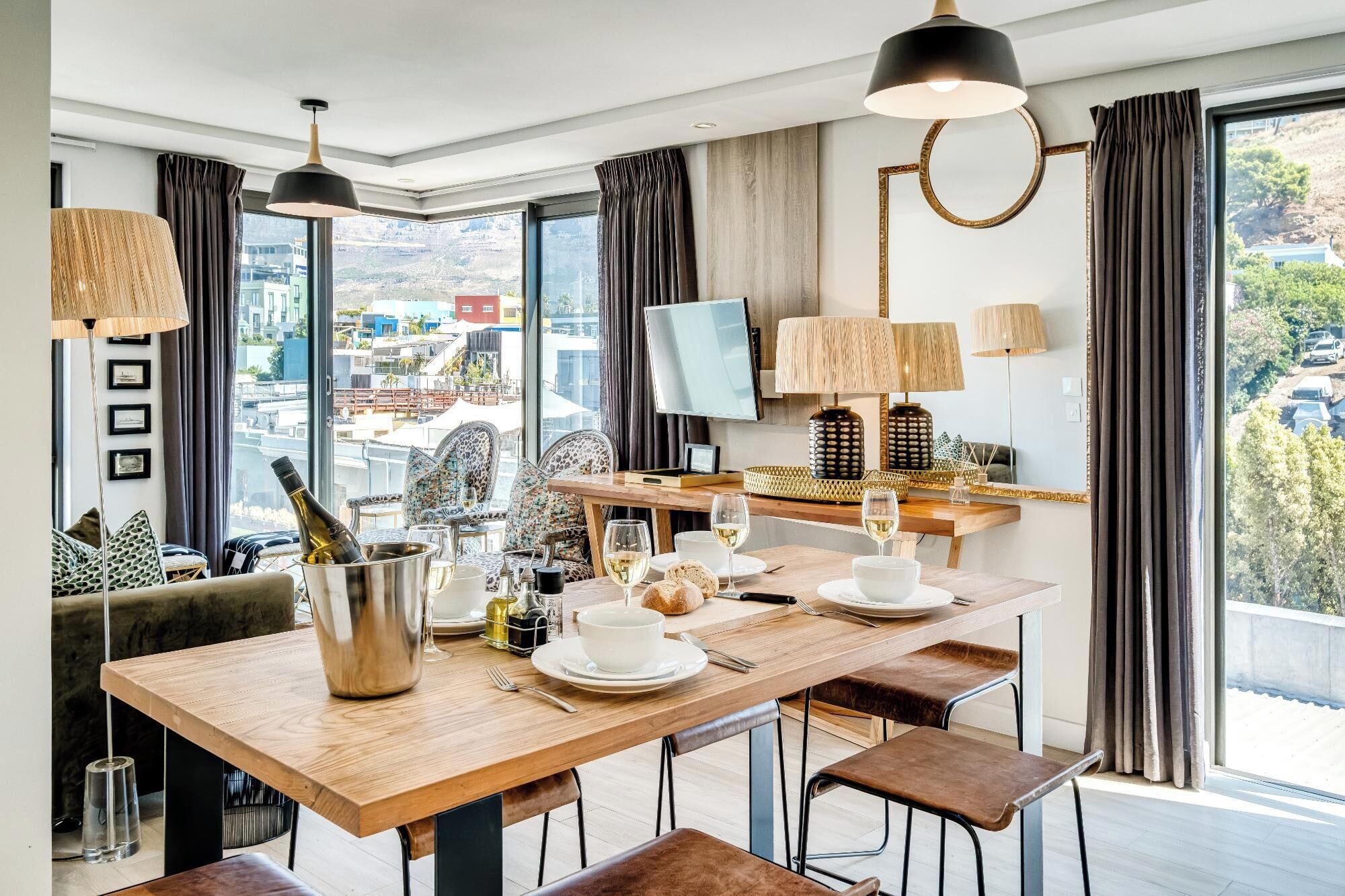 A modern dining area with a wooden table, chairs, and a TV.