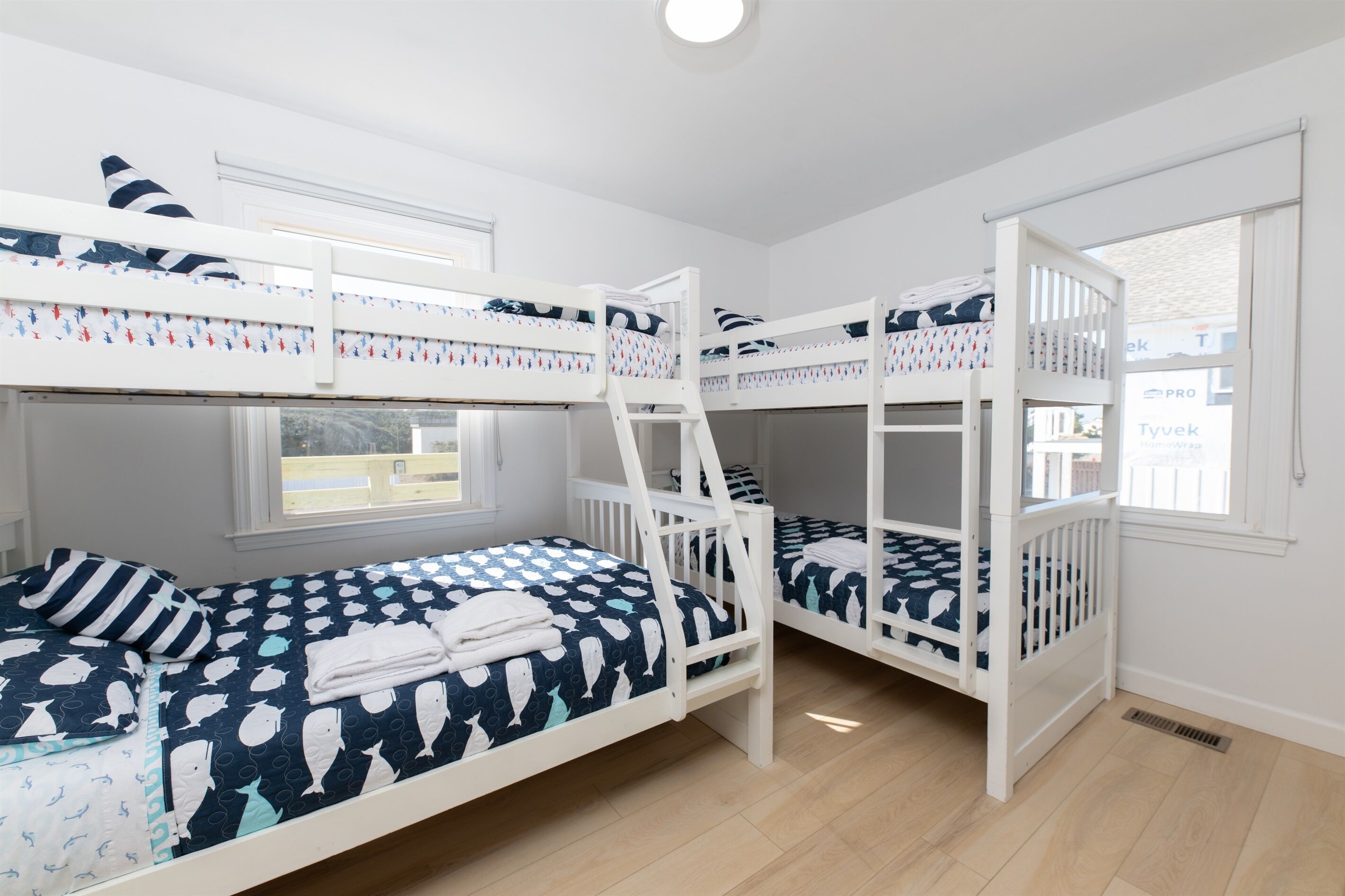 A room with bunk beds, a window, and a door.