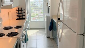 A modern kitchen with white appliances, a stove, and a refrigerator.