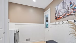 A laundry room with a washing machine, a drying rack, and a bench. - Destined for Relaxation (Saugatuck)