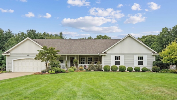 A single-story house with a garage, a covered porch, and a well-maintained lawn. - Destined for Relaxation (Saugatuck)