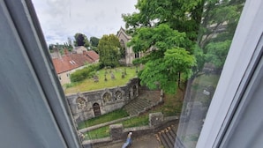 Une vue d’un cimetière avec un mur de pierre et une église en arrière-plan.