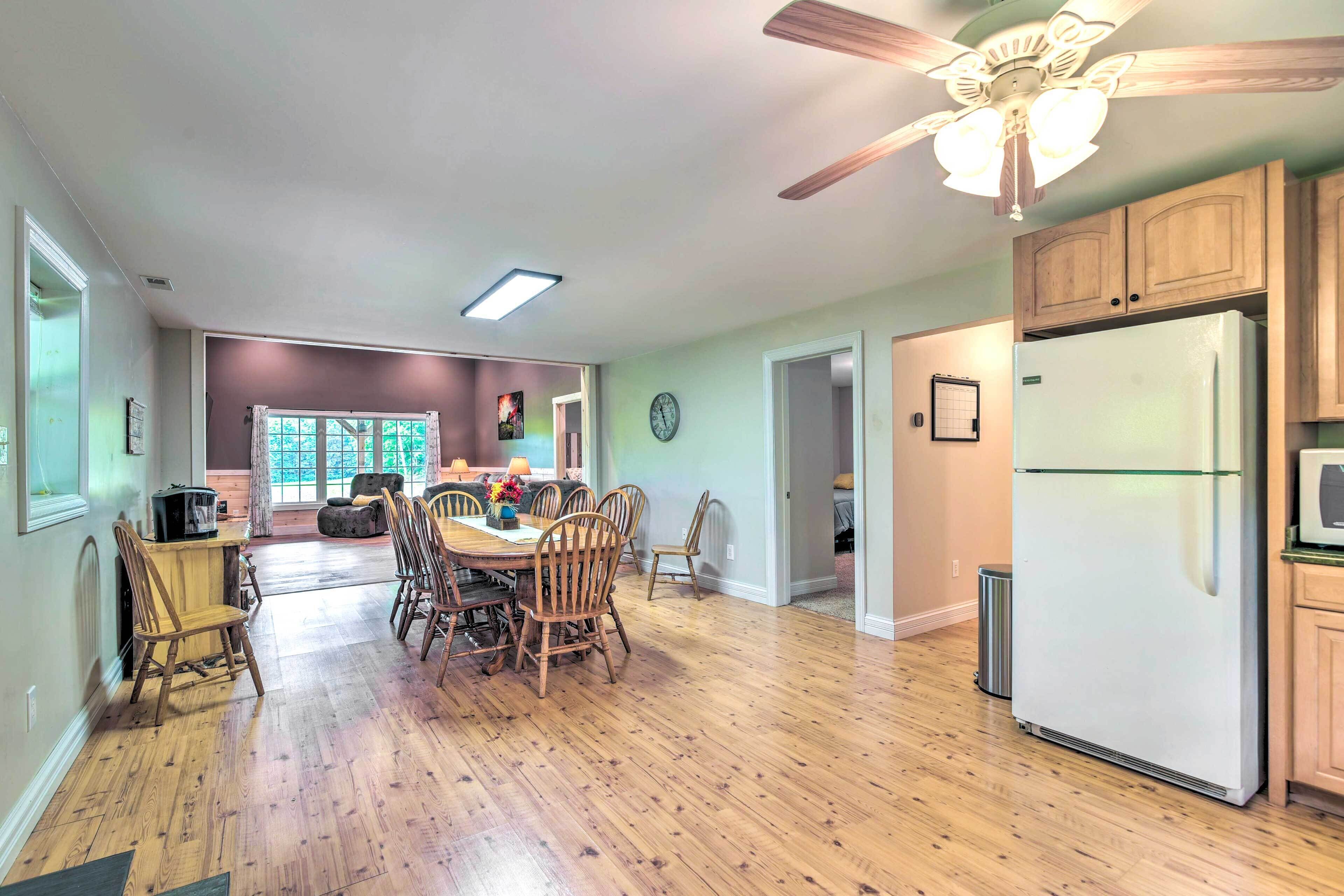 A spacious kitchen with wooden cabinets, a refrigerator, and a dining area with wooden chairs and a table.