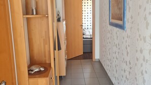 En hall med trämöbler, ett klinkergolv och en vägg med ett mönster.