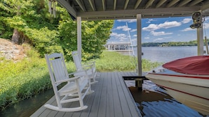 A wooden dock with rocking chairs and a boat. - MAIN LAKE VIEWS - Fire Pit - Kayaks, SUPs - Pool Table - Bikes (Littleton)