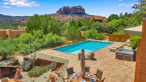 A pool area with a view of red rock formations, surrounded by greenery and outdoor furniture. - Resort Style Retreat, Red Rock Views Inside & Out+Salt Water Pool+Hot Tub (Sedona)