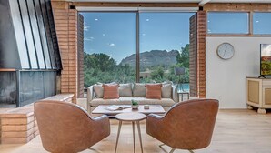 A modern living room with a sofa, two chairs, a coffee table, and a fireplace. - Resort Style Retreat, Red Rock Views Inside & Out+Salt Water Pool+Hot Tub (Sedona)