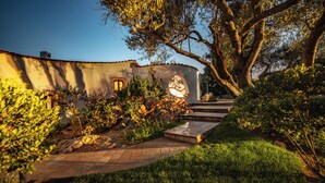 A garden pathway leading to a building with a stone staircase and a circular window. - Villa Isa 6, Emma Villas (Altura)