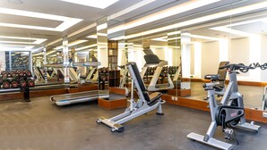 A modern gym with various exercise equipment, including treadmills and weight machines, and a large mirror wall. - One hotel Casablanca (Casablanca)