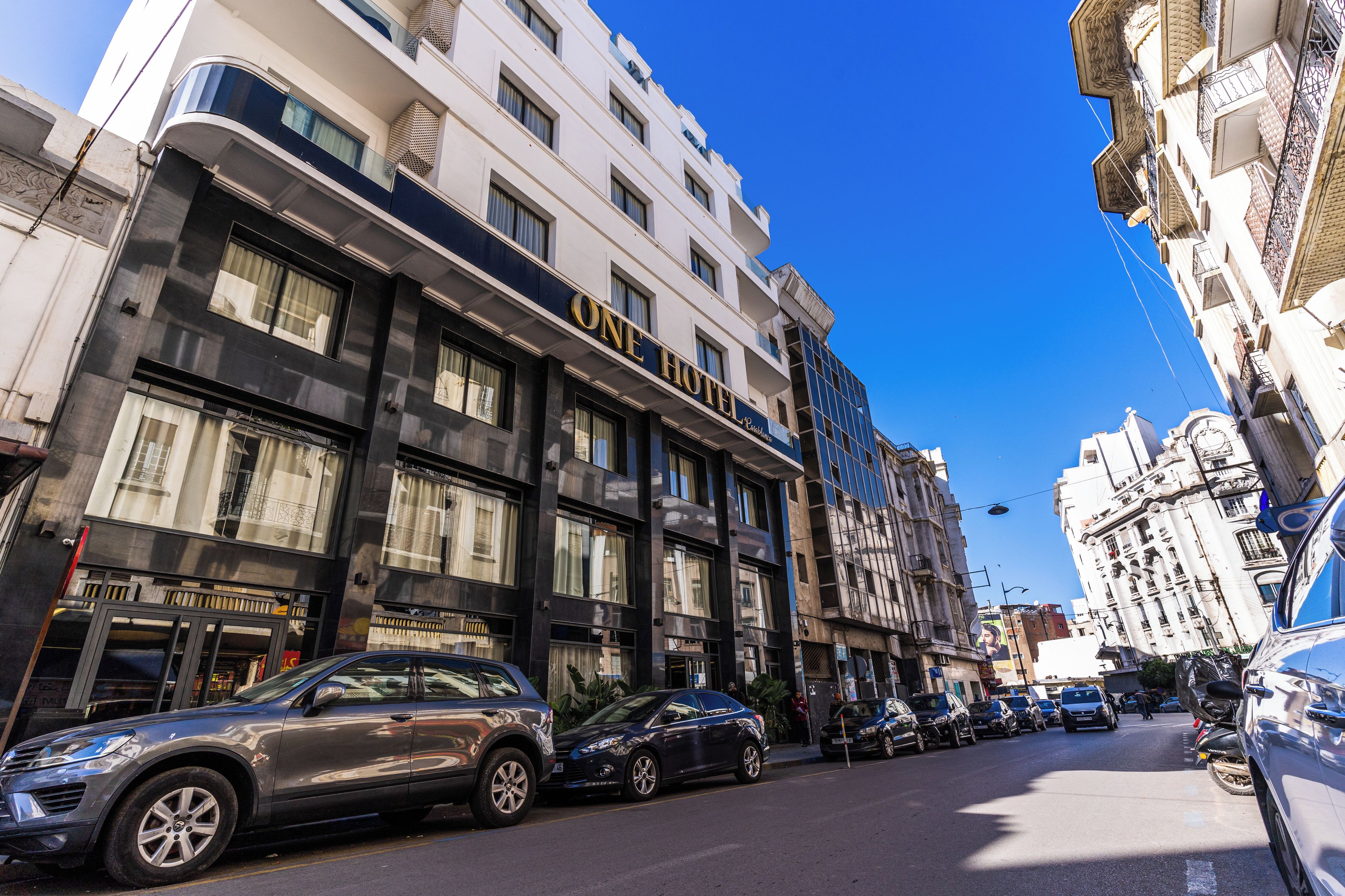 Un hotel con fachada moderna, múltiples ventanas y un llamativo letrero que dice 'HOTEL'.