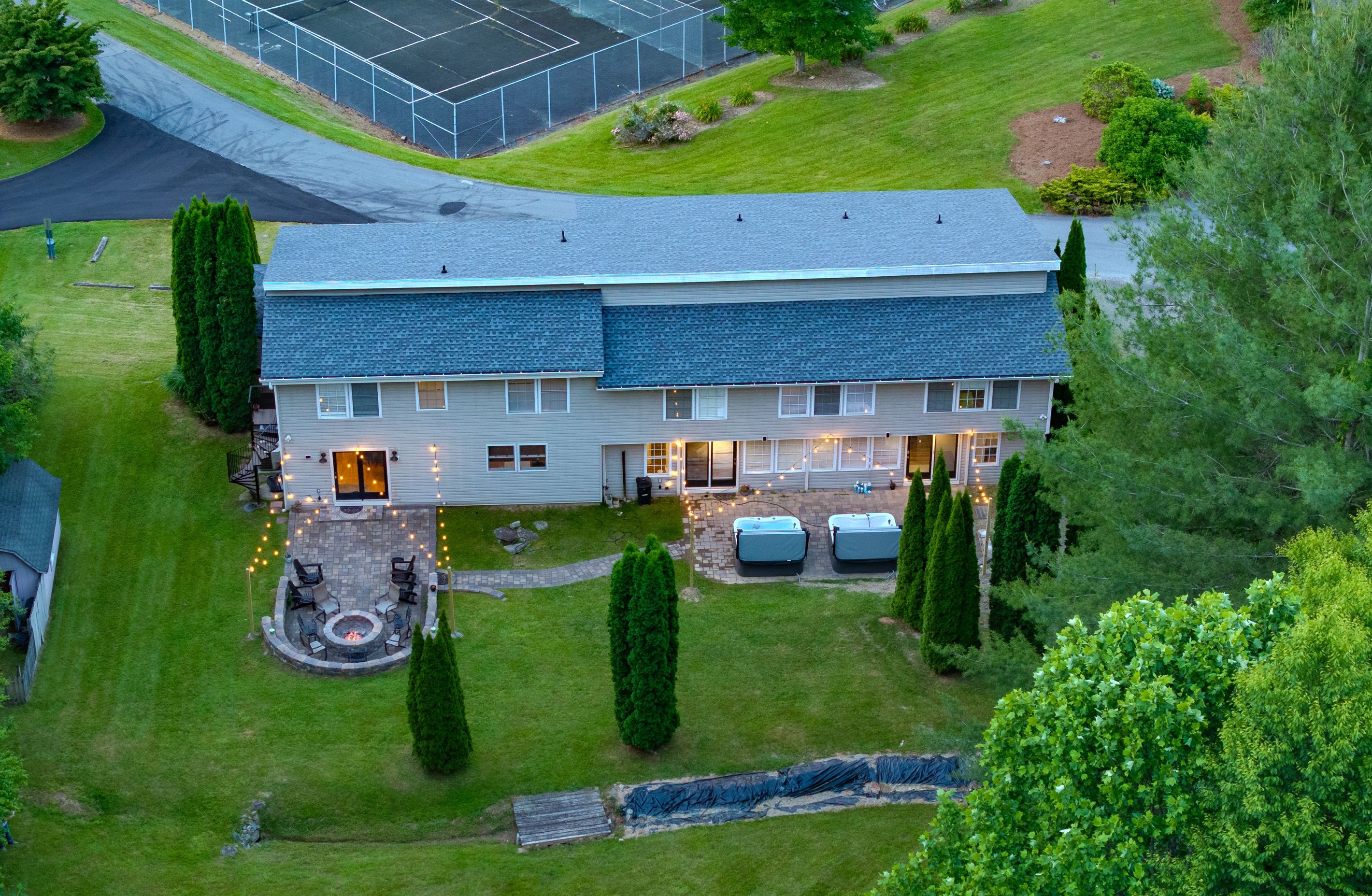 Une maison à deux étages dotée d’un patio et d’un espace extérieur aménagé pour s’asseoir.