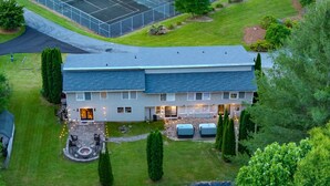 A two-story house with a patio and outdoor seating area.