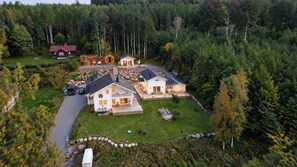A residential area with multiple houses surrounded by dense forest.