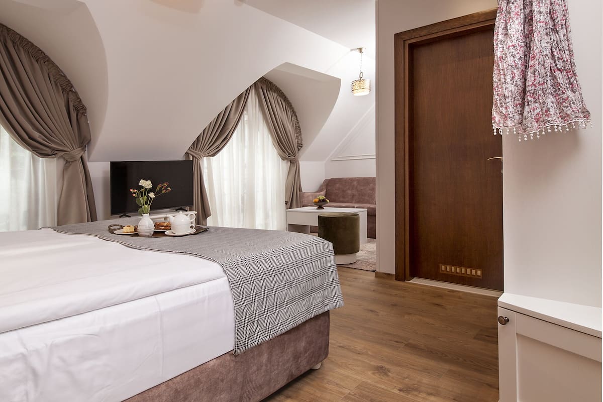 Ein Schlafzimmer mit einem Bett, einem Fernseher, einem Nachttisch mit Lampe und einem Kleiderschrank.