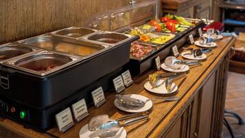 A buffet with various food options, including bacon, sausage, and eggs.