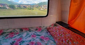 Enjoy a peaceful rural view from this cozy space with a comfortable bed and floral accents.