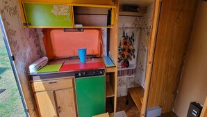 A compact kitchen with a sink, a small countertop, and a cabinet.