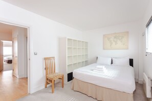 Une chambre à coucher avec un lit, une chaise, une armoire et une carte du monde accrochée au mur.