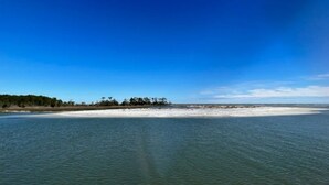 A coastal view with a sandy beach and a clear blue sky.