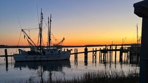 A fishing boat docked at a pier during sunset.