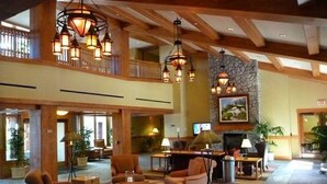 A spacious lobby with multiple seating areas, a fireplace, and a stone accent wall. - MARRIOTT Resort AUG 26,27 -130 USD-Hot tub -GYM -Kitchen (South Lake Tahoe)