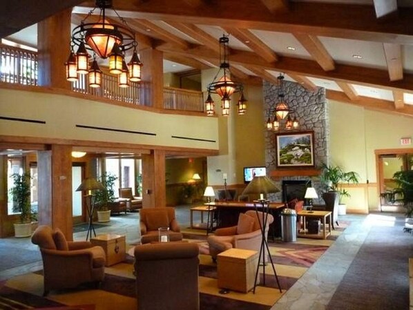 A spacious lobby with multiple seating areas, a fireplace, and a stone accent wall. - 225 dollars AUG 23-26 MARRIOTT Hot tub GYM Kitchen (South Lake Tahoe)