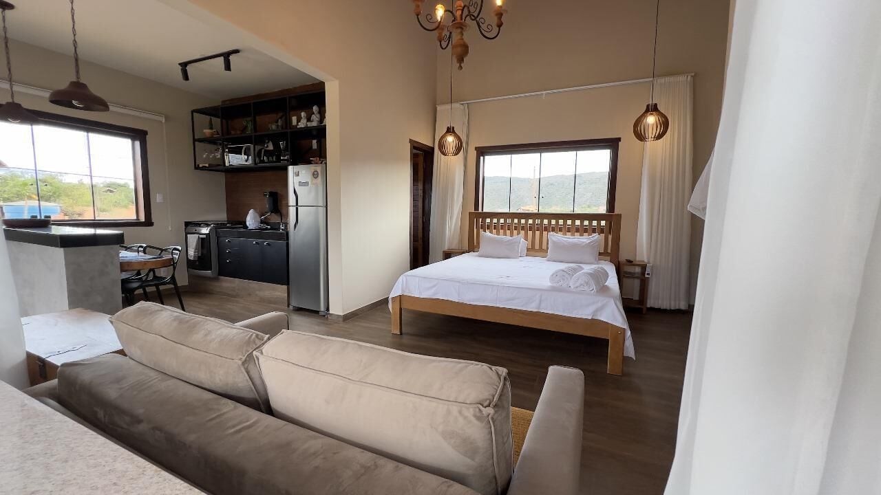 Un dormitorio con una cama grande, cabecera de madera y vistas al exterior.